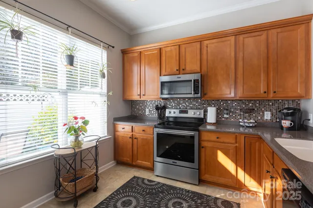 a kitchen with stainless steel appliances granite countertop a sink stove and cabinets