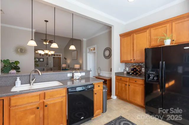 a kitchen with stainless steel appliances kitchen island granite countertop a sink refrigerator and cabinets