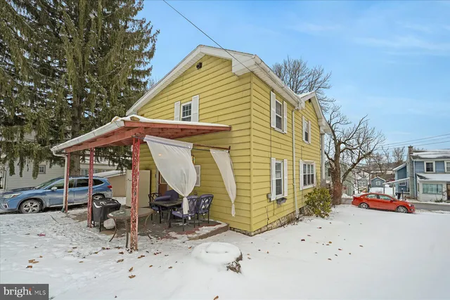 a view of a blue house with a yard