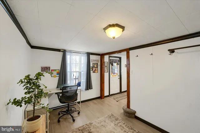 a view of a workspace with furniture and a window