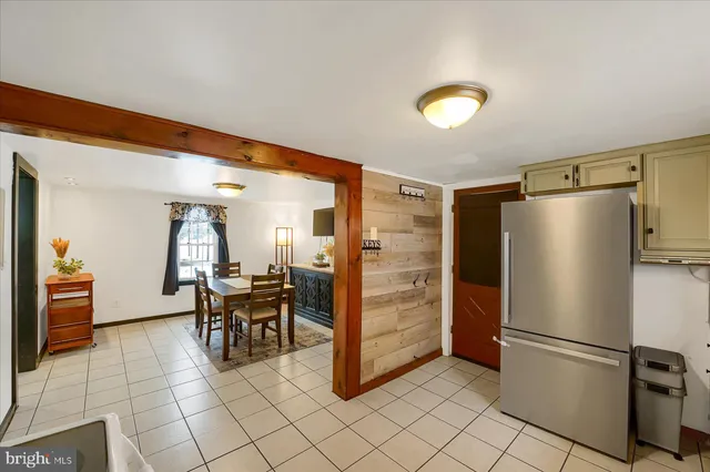 a kitchen with stainless steel appliances kitchen island granite countertop dining table chair and a refrigerator
