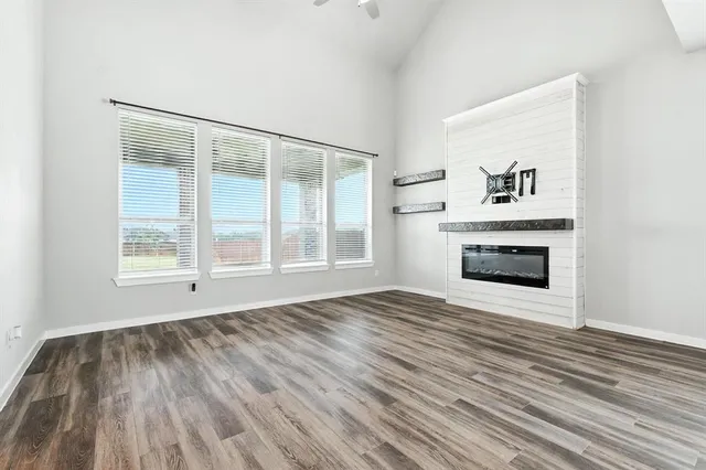 a view of empty room with wooden floor and fireplace