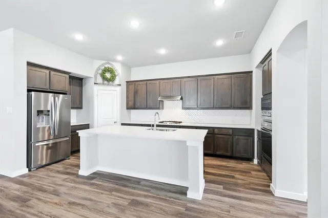 a kitchen with stainless steel appliances granite countertop a refrigerator stove and oven