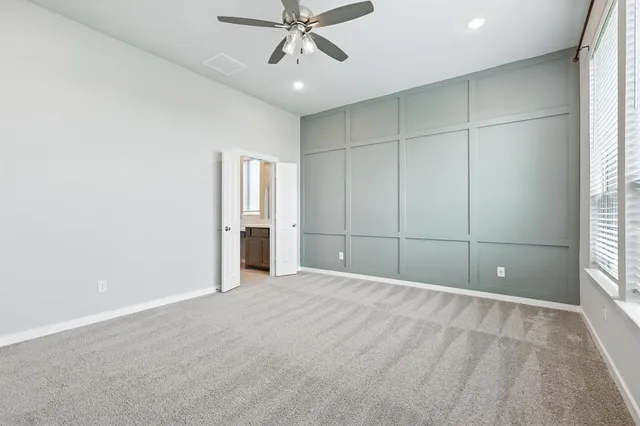 an empty room with fan and windows