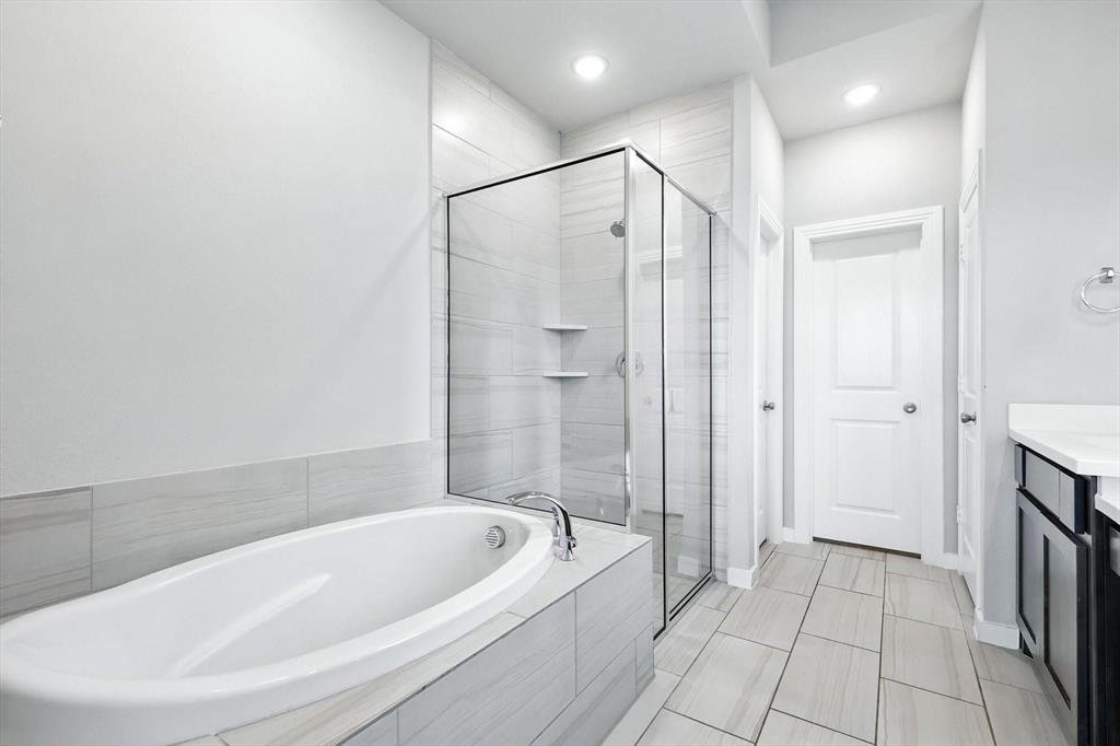 4203 Parrot Lane Sherman, TX 75092 - Photo 22 of 38 a bathroom with a bathtub and a shower