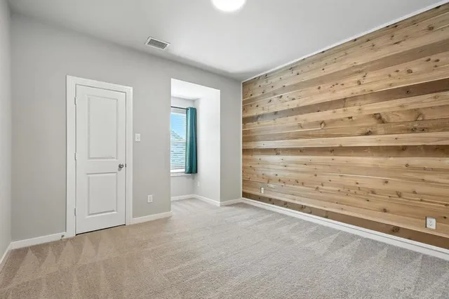 a view of an empty room with cabinet and mirror