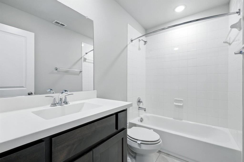 4203 Parrot Lane Sherman, TX 75092 - Photo 33 of 38 a bathroom with a sink a toilet and a bathtub