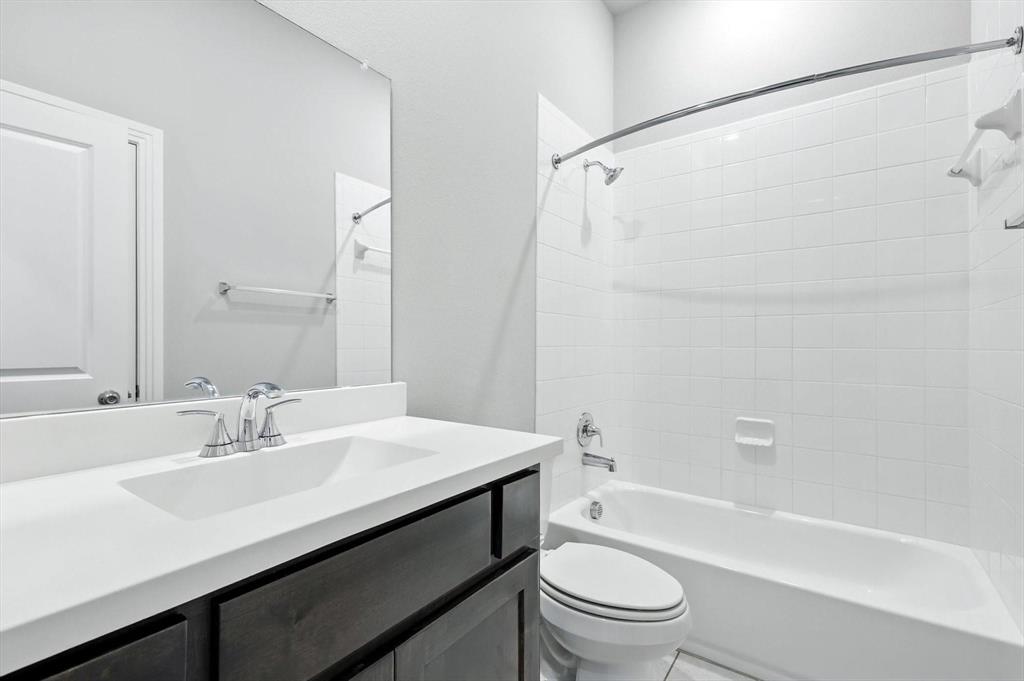 4203 Parrot Lane Sherman, TX 75092 - Photo 4 of 38 a bathroom with a sink a toilet and a bathtub