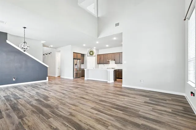a view of a kitchen with kitchen island a sink wooden floor and a fireplace