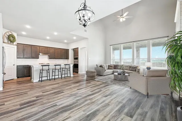 a living room with furniture a fireplace and a dining table with wooden floor