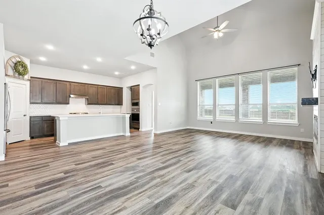 a view of a kitchen with a sink and dishwasher a refrigerator with wooden floor