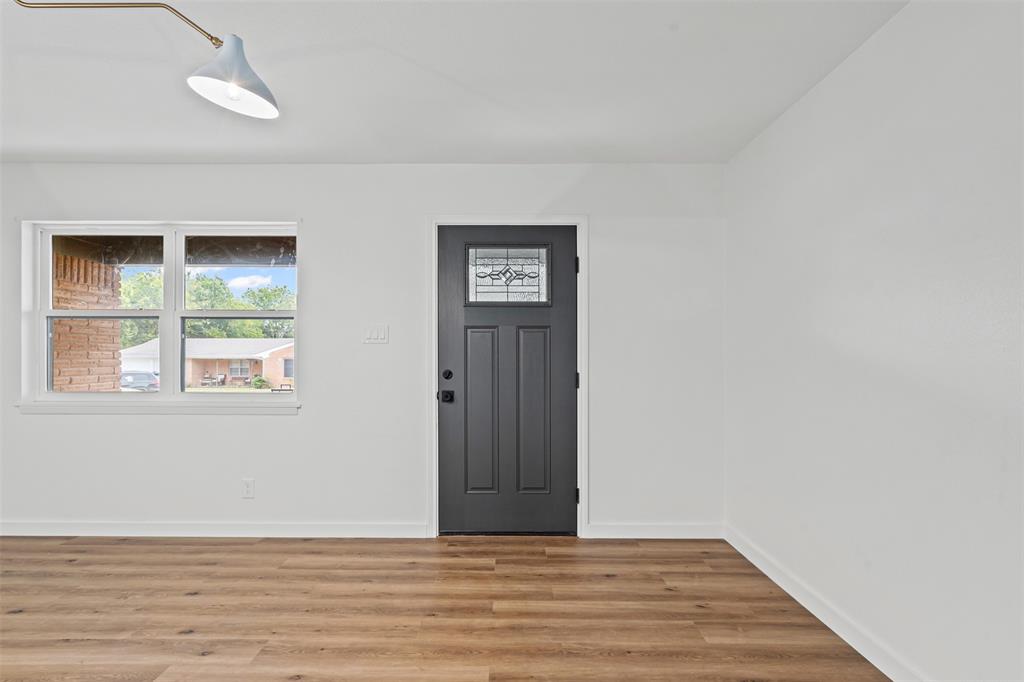 4920 Rector Avenue Fort Worth, TX 76133 - Photo 9 of 37 an empty room with wooden floor and windows