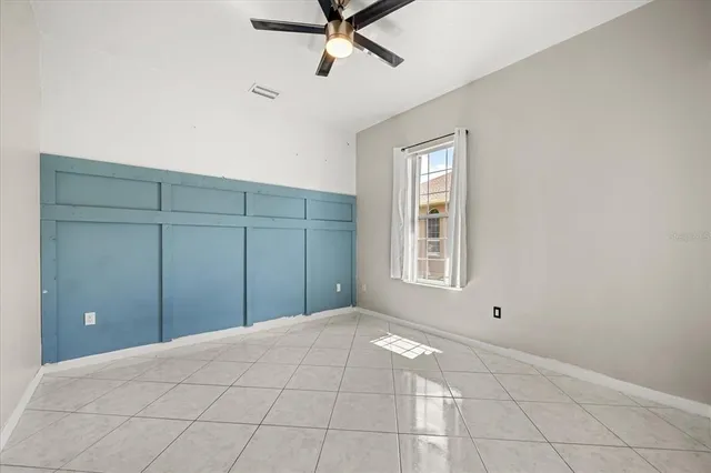 a spacious bedroom with a bed and a flat screen tv