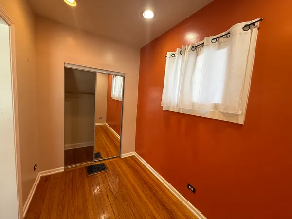 a view of a room with wooden floor and fan