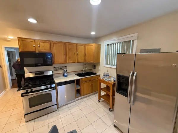 a kitchen with granite countertop a stove a sink and a microwave