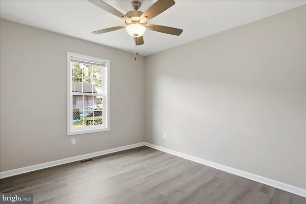 an empty room with a window and a fan