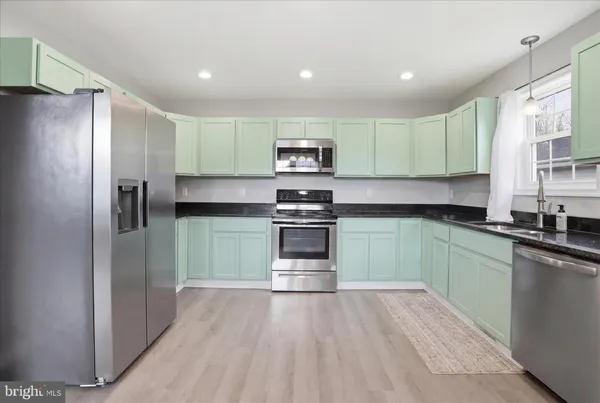 a kitchen with granite countertop a refrigerator and a sink