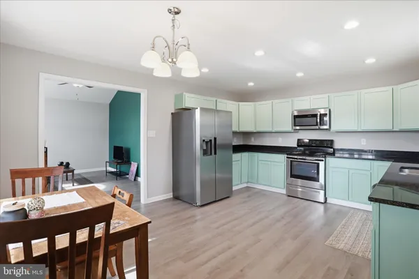 a kitchen with a center island wooden floor and stainless steel appliances