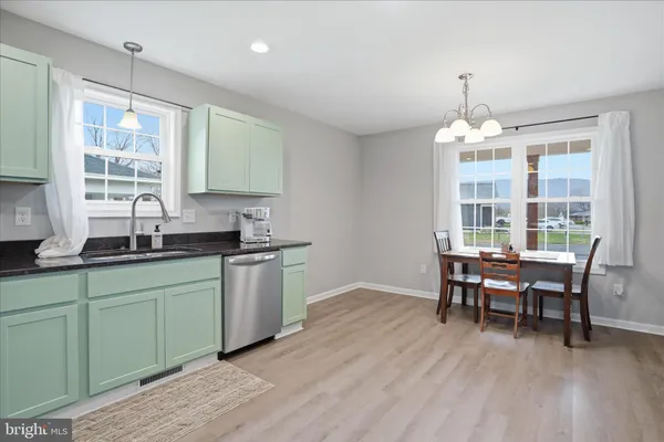 a kitchen with granite countertop a sink dining table and chairs