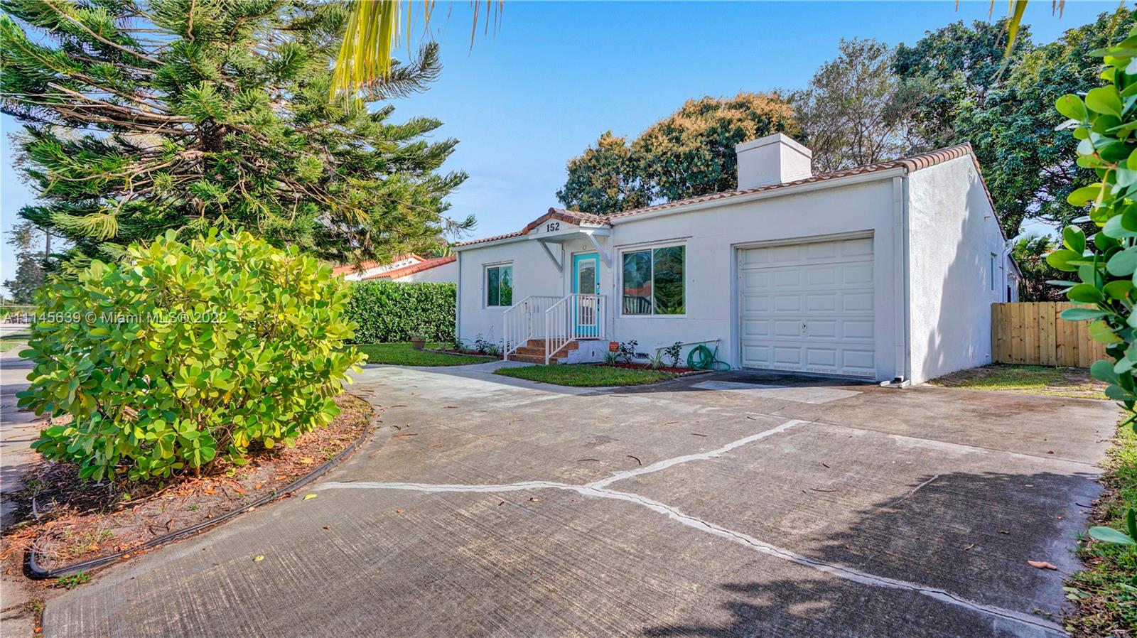 152 Northwest 103rd Street Miami Shores, FL 33150 - Photo 2 of 27 a view of a house with a yard and garage