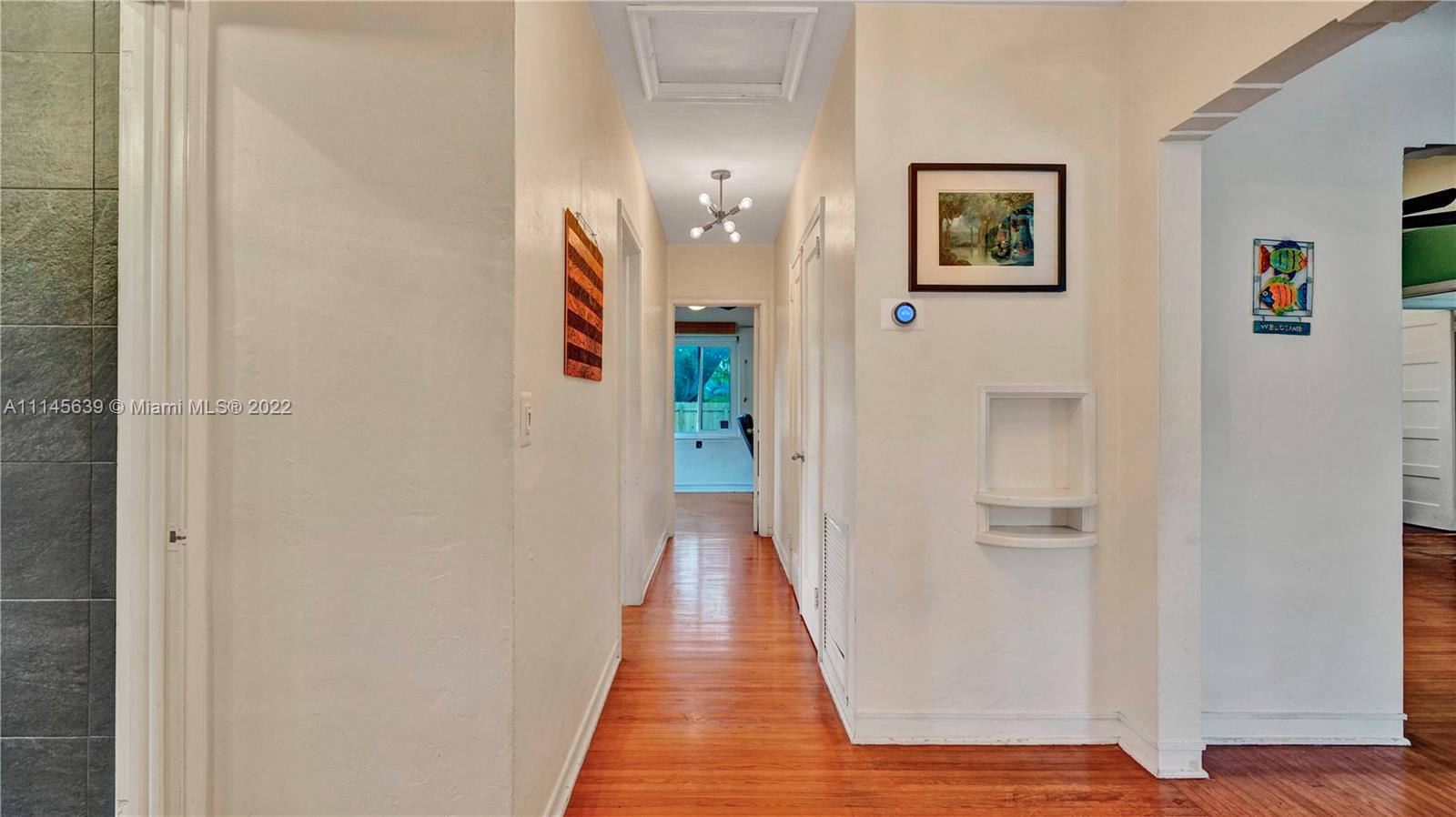 152 Northwest 103rd Street Miami Shores, FL 33150 - Photo 21 of 27 a view of a hallway with wooden floor and stairs