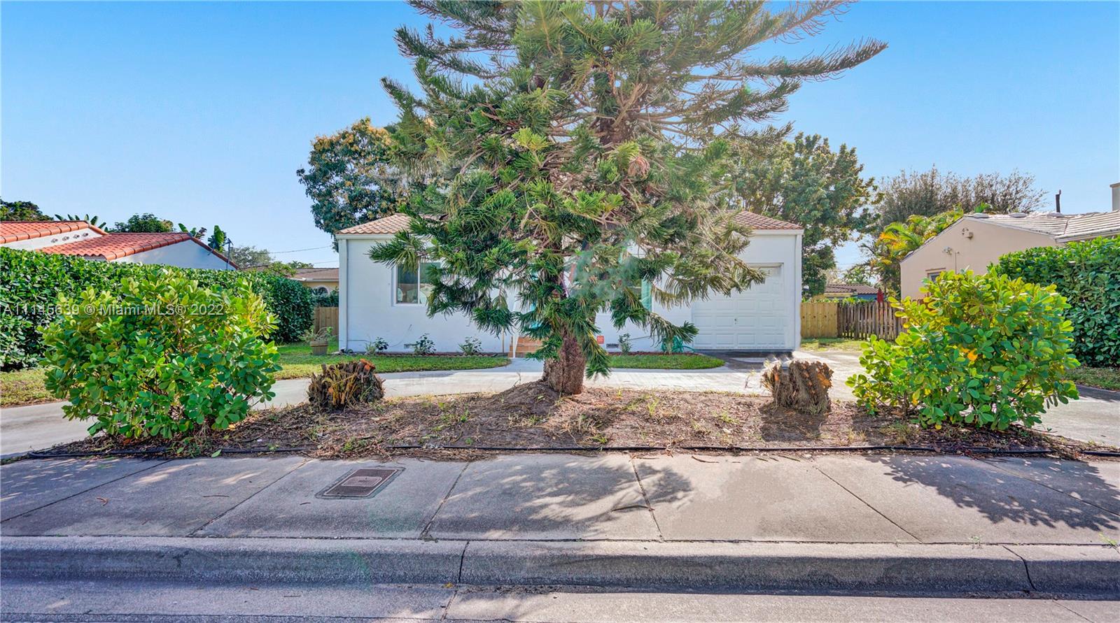 152 Northwest 103rd Street Miami Shores, FL 33150 - Photo 7 of 27 a front view of a house with garden