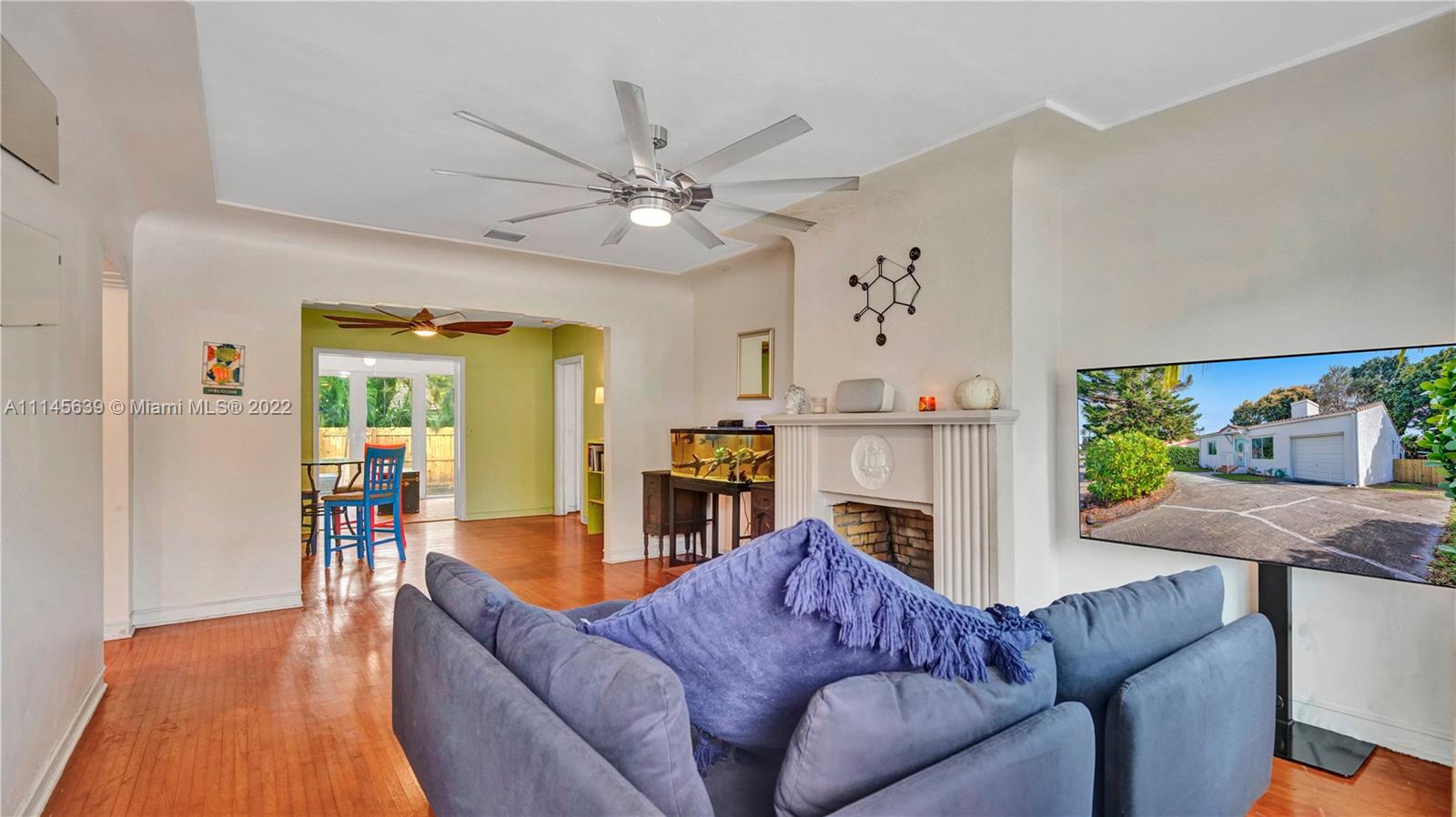 152 Northwest 103rd Street Miami Shores, FL 33150 - Photo 9 of 27 a living room with furniture a fireplace and a flat screen tv