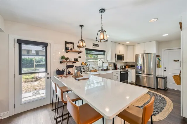 a view of a dining room and livingroom with furniture wooden floor a chandelier