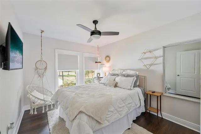 a bedroom with a bed a window and a flat screen television