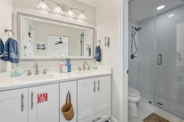 a bathroom with a granite countertop toilet sink and mirror