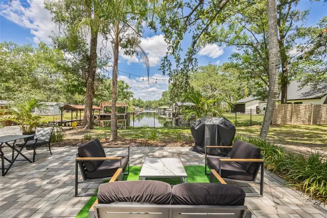 a backyard of a house with garden and outdoor seating
