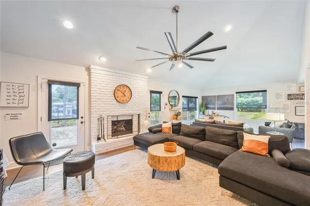a living room with furniture a fireplace and a large window