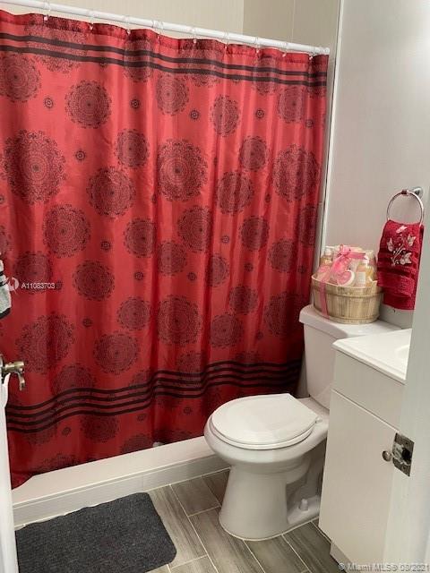 15619 Southwest 73rd Cir Terrace, Unit 106 Miami, FL 33193 - Photo 11 of 18 a white toilet sitting next to a shower curtain