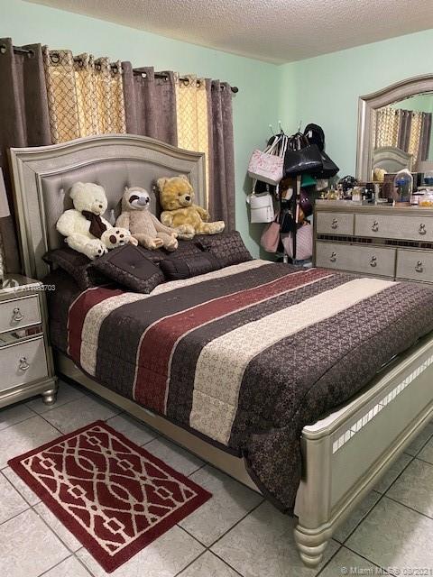 15619 Southwest 73rd Cir Terrace, Unit 106 Miami, FL 33193 - Photo 13 of 18 a bed room with a bed and a couch