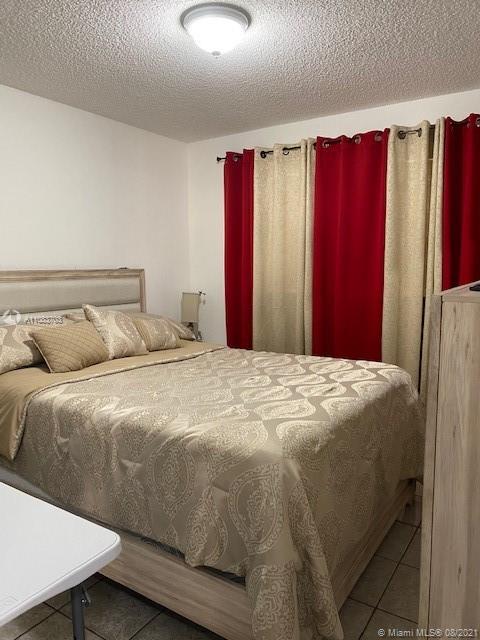 15619 Southwest 73rd Cir Terrace, Unit 106 Miami, FL 33193 - Photo 17 of 18 a bedroom with a bed and a window