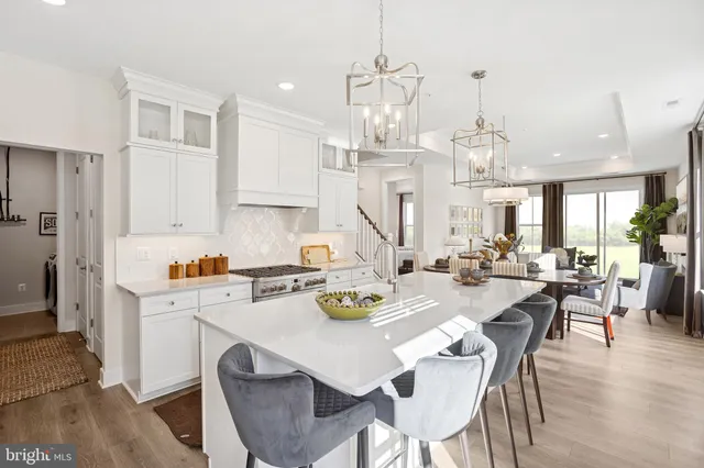 a view of a dining room and livingroom with furniture wooden floor a chandelier