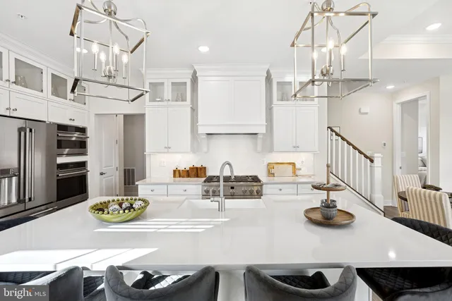 a kitchen with stainless steel appliances a table chairs and a chandelier