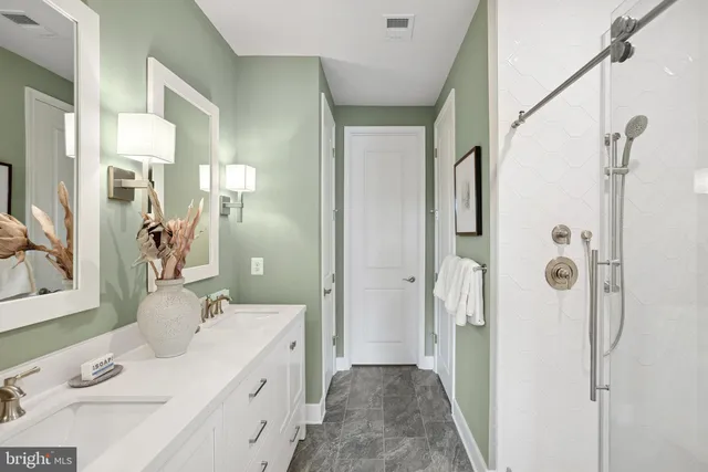 a bathroom with a double vanity sink mirror and shower