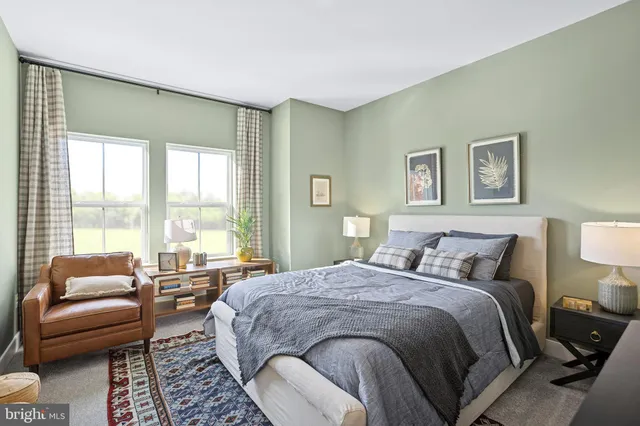 a spacious bedroom with a bed a couch and a large window