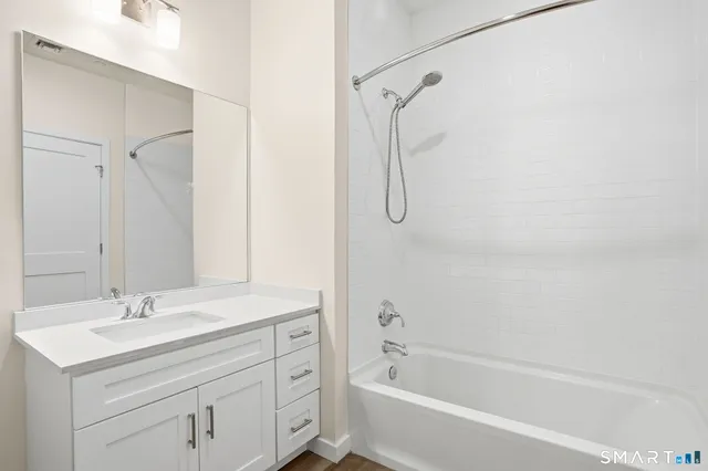 a bathroom with a sink double vanity mirror and a bathtub