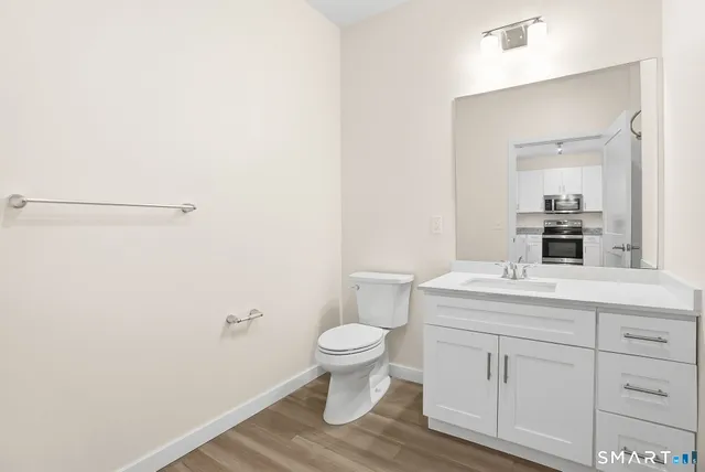 a bathroom with a toilet a sink and a mirror