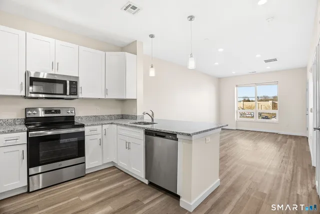 a kitchen with stainless steel appliances granite countertop a stove and a microwave