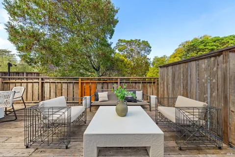 a view of a patio with couches table and chairs and potted plants