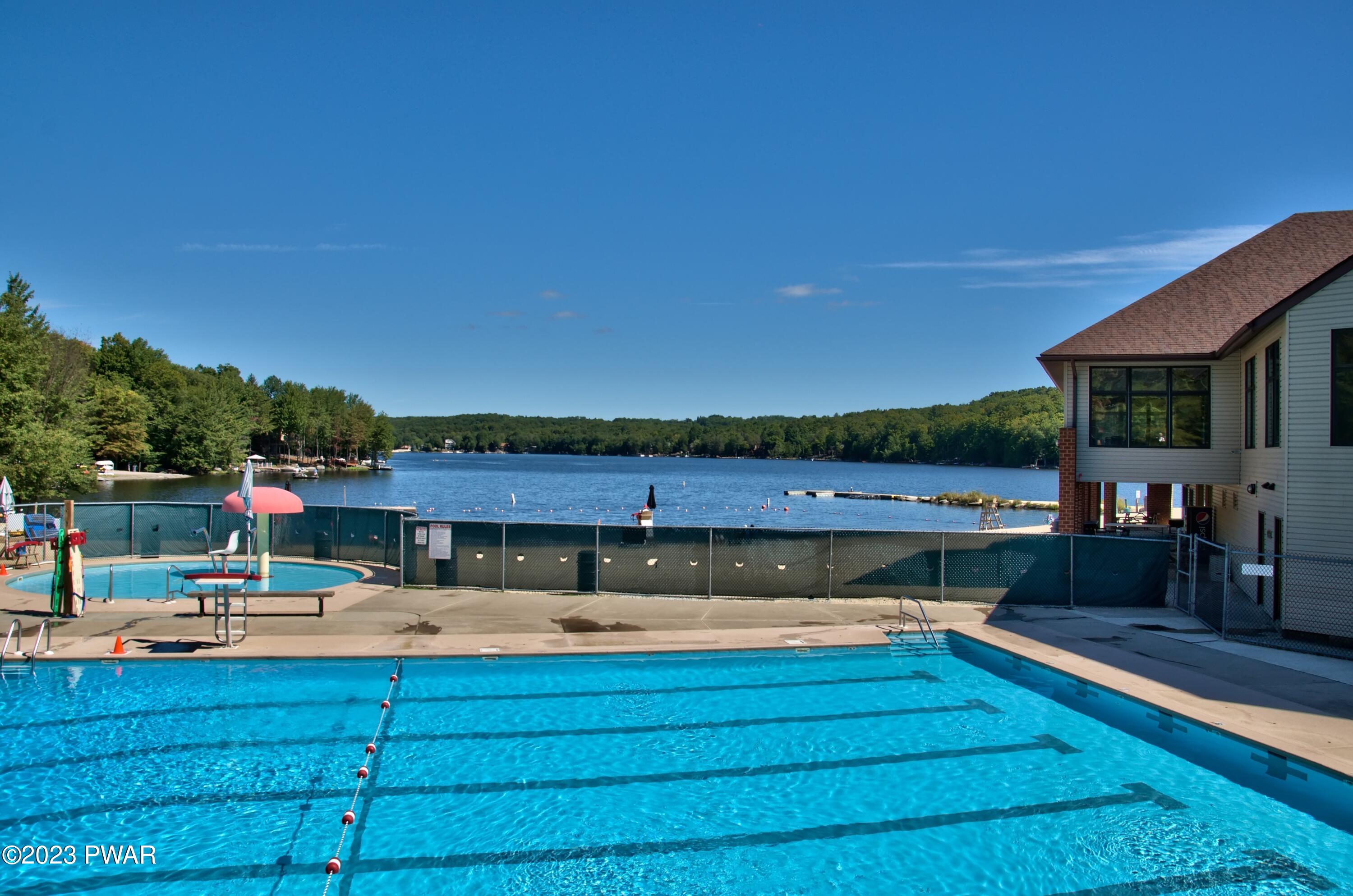 3041 Northgate Road Lake Ariel, PA 18436 - Photo 70 of 98 a view of a swimming pool with a table and chairs under an umbrella