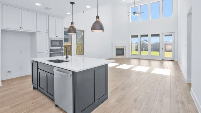 a kitchen with a sink a stove and wooden floor
