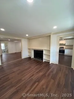 a view of empty room with wooden floor and fireplace