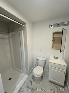 a bathroom with a toilet sink vanity and shower