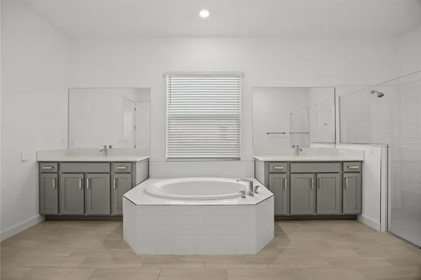 a spacious bathroom with a tub sink and mirror