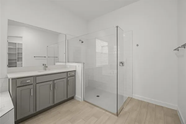 a spacious bathroom with a shower sink and mirror