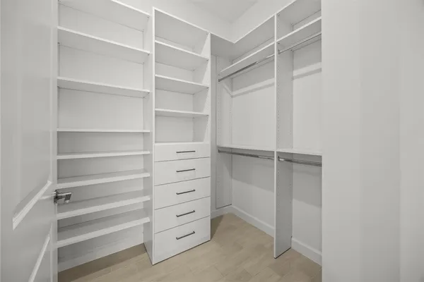 a view of walk in closet with empty racks